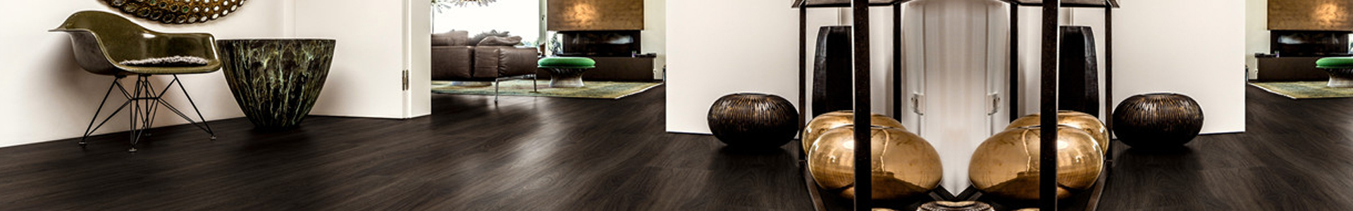 Ornato Urban Hybrid waterproof flooring in dark tones, showcasing modern interior design elements, including decorative bowls and a stylish chair, suitable for various interior spaces.