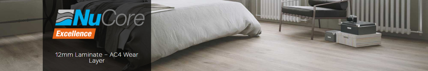 NuCore Excellence 12mm laminate flooring featuring AC4 wear layer in a modern bedroom setting with a bed, chair, and decorative boxes.