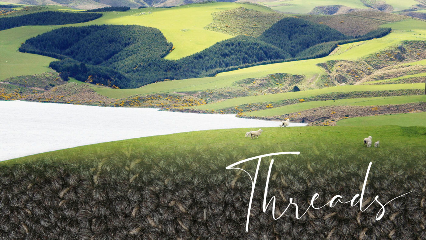 Landscape featuring lush green hills and a serene lake, with sheep grazing, and the word "Threads" overlaying a textured carpet design, representing Lux Flooring's prestige carpet collection.